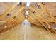 Exposed rafters and a plywood floor create an open, unfinished attic space at 34682 Stampede Cir, Elizabeth, CO 80107