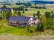 Aerial view of the home's back exterior, featuring a two-level deck and patio, and lush landscaping at 34682 Stampede Cir, Elizabeth, CO 80107