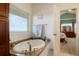 The luxurious bathroom features a soaking tub with a granite surround, and an ensuite bedroom at 34682 Stampede Cir, Elizabeth, CO 80107