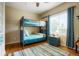 Bedroom with bunkbeds and hardwood floors is bathed in natural light at 34682 Stampede Cir, Elizabeth, CO 80107