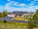 A beautiful exterior elevation showcasing the front of the home with a large driveway and manicured lawn at 34682 Stampede Cir, Elizabeth, CO 80107