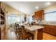 Bright, open kitchen featuring a central island, stainless steel appliances and a breakfast nook with wooded views at 34682 Stampede Cir, Elizabeth, CO 80107