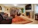Cozy living room with a stone fireplace, built-in bookshelves, and comfortable leather seating at 34682 Stampede Cir, Elizabeth, CO 80107