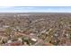 Expansive aerial view showcasing a residential neighborhood with mature trees and a distant lake at 3327 Irving St, Denver, CO 80211