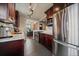 Open concept kitchen with granite counters, stainless appliances, and dark wood cabinets at 3327 Irving St, Denver, CO 80211