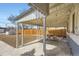 The backyard has a covered patio, picnic table, gravel landscaping, and wooden fence at 3385 Olive St, Denver, CO 80207