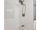 This tiled shower features a rainfall shower head, hand held sprayer, and mosaic tiled backsplash at 3385 Olive St, Denver, CO 80207