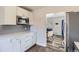 Chic kitchen design with stainless steel microwave and white cabinetry, leading into the living room at 3385 Olive St, Denver, CO 80207