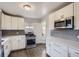 Bright kitchen with white cabinetry, stainless steel appliances, and a stylish backsplash at 3385 Olive St, Denver, CO 80207
