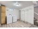 The laundry room features a washer, dryer, storage cabinet, shelving and wood-look floors at 3385 Olive St, Denver, CO 80207