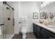 This elegant bathroom features a glass shower door, sleek dark vanity, and stylish modern design with white counter tops at 18633 Stroh Rd # 2-104, Parker, CO 80134