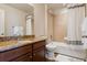Bathroom features granite counters, dark wood cabinets, and a shower-tub combo with tile surround at 9456 Rockhurst St # F, Highlands Ranch, CO 80129
