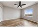 Bedroom features wood floors, ceiling fan, and a large window overlooking the community at 9456 Rockhurst St # F, Highlands Ranch, CO 80129