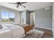 Bright bedroom features wood floors, ceiling fan, and a large window overlooking the community at 9456 Rockhurst St # F, Highlands Ranch, CO 80129