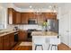 Well-equipped kitchen with wooden cabinetry, granite countertops, stainless steel appliances, and a stylish kitchen island at 9456 Rockhurst St # F, Highlands Ranch, CO 80129