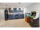 Entertaining basement with custom cabinets, wet bar, arcade game, and punching bag at 6155 Puma Pt, Lone Tree, CO 80124