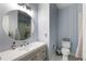 Bathroom featuring sleek grey vanity, round mirror and shower with glass door at 6155 Puma Pt, Lone Tree, CO 80124