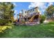 Exterior backyard of home featuring a two-story deck, stone patio and beautiful grass at 6155 Puma Pt, Lone Tree, CO 80124