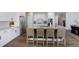 Stylish kitchen with white cabinets, stainless steel appliances, large center island with seating, and hardwood floors at 6155 Puma Pt, Lone Tree, CO 80124
