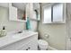 Neutral-toned bathroom with white vanity, a frosted window, and shower with gray tile at 228 Birch Ave, Castle Rock, CO 80104