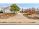 Long driveway leading to a detached two-car garage with mature trees in the front yard at 228 Birch Ave, Castle Rock, CO 80104