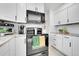 Bright, modern kitchen featuring white cabinets, black appliances, granite countertops, and tiled floors at 228 Birch Ave, Castle Rock, CO 80104