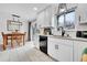 Bright kitchen with white cabinets, granite countertops, stainless steel dishwasher, and modern black hardware at 228 Birch Ave, Castle Rock, CO 80104