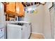 Clean laundry room with front loading washer and dryer, overhead storage, and cleaning supplies at 228 Birch Ave, Castle Rock, CO 80104