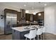 Well-equipped kitchen with dark wood cabinetry, stainless steel appliances, and a large center island with seating at 23030 E Del Norte Cir, Aurora, CO 80016