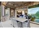 Covered outdoor patio with dining table, stone pillars and open view to the interior of the home at 23030 E Del Norte Cir, Aurora, CO 80016