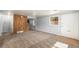 Open living room features neutral paint, plush carpeting, and a wood accent wall, perfect for relaxation at 444 S Jersey St, Denver, CO 80224