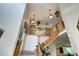 High ceiling over an open staircase with wood railing, plants, and artwork at 1313 Iris Cir, Broomfield, CO 80020