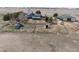 Aerial view of a gray house, a green roofed barn, other outbuildings, and multiple fenced areas at 5910 Mccart Ranch Cir, Elizabeth, CO 80107