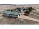 Aerial view of a property with a large green roofed barn, a gray house, and an outbuilding at 5910 Mccart Ranch Cir, Elizabeth, CO 80107
