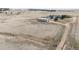 Distant aerial view of a property with a large green roofed barn, a gray house, and surrounding acreage at 5910 Mccart Ranch Cir, Elizabeth, CO 80107