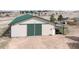 Exterior of a large barn with green roof and white siding and large access doors at 5910 Mccart Ranch Cir, Elizabeth, CO 80107