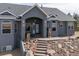 View of the home's attractive front porch and covered entry with a stone statue accent at 5910 Mccart Ranch Cir, Elizabeth, CO 80107