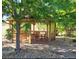 A relaxing outdoor gazebo featuring a wooden table and seating, nestled under the shade of a mature tree at 5910 Mccart Ranch Cir, Elizabeth, CO 80107