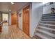 Inviting hallway featuring wood-look flooring, wooden doors, and a carpeted staircase to the upper level at 5910 Mccart Ranch Cir, Elizabeth, CO 80107