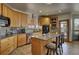 Eat-in kitchen featuring wooden cabinets, an island with seating, and granite counters at 5910 Mccart Ranch Cir, Elizabeth, CO 80107