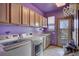 Well-equipped laundry room with modern appliances and storage, with a view outside to the deck at 5910 Mccart Ranch Cir, Elizabeth, CO 80107