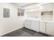 Well-lit laundry room with washer, dryer, cabinet space, black rubber flooring and small window at 6762 E Briarwood Dr, Centennial, CO 80112