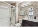 Bathroom with shower and glass door, mosaic backsplash, dark vanity, and sink at 1663 W 135Th Way, Denver, CO 80234