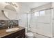 Bathroom featuring mosaic backsplash, granite countertop, and glass door shower at 1663 W 135Th Way, Denver, CO 80234