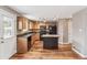 Kitchen featuring hardwood floors, granite countertops, light wood cabinets and black appliances at 1663 W 135Th Way, Denver, CO 80234