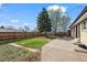 Spacious backyard featuring a concrete patio, large tree, and a wooden privacy fence at 7496 Clay St, Westminster, CO 80030