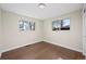 Empty bedroom with hardwood floors, two windows, and neutral paint, offering a blank canvas at 7496 Clay St, Westminster, CO 80030
