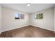 Empty bedroom with hardwood floors, two windows, and neutral paint, offering a blank canvas at 7496 Clay St, Westminster, CO 80030
