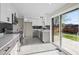Bright kitchen with stainless appliances, gray cabinets, and sliding doors to the backyard at 7496 Clay St, Westminster, CO 80030
