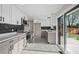 Modern kitchen with stainless steel appliances, gray cabinets, and sliding glass doors to the backyard at 7496 Clay St, Westminster, CO 80030